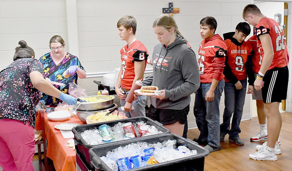 The Sandhills Care Center hosted a Tailgate Party for Ainsworth High School Athletes to celebrate their fall sports seasons. The Tailgate Party was held at the Care Center on Monday, November 7th. Athletes were served hamburgers and hot dogs along with potato salad and drinks. During the evening, the athletes were able chat with residents while enjoying their supper.